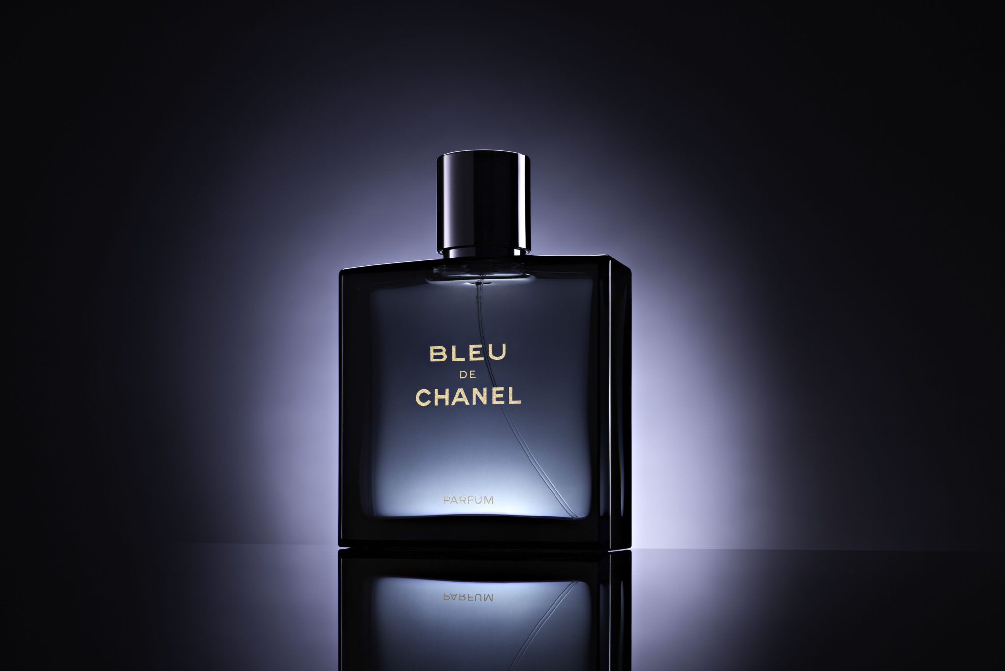 a full bottle of Bleu De Chanel perfume shot in studio with a black background