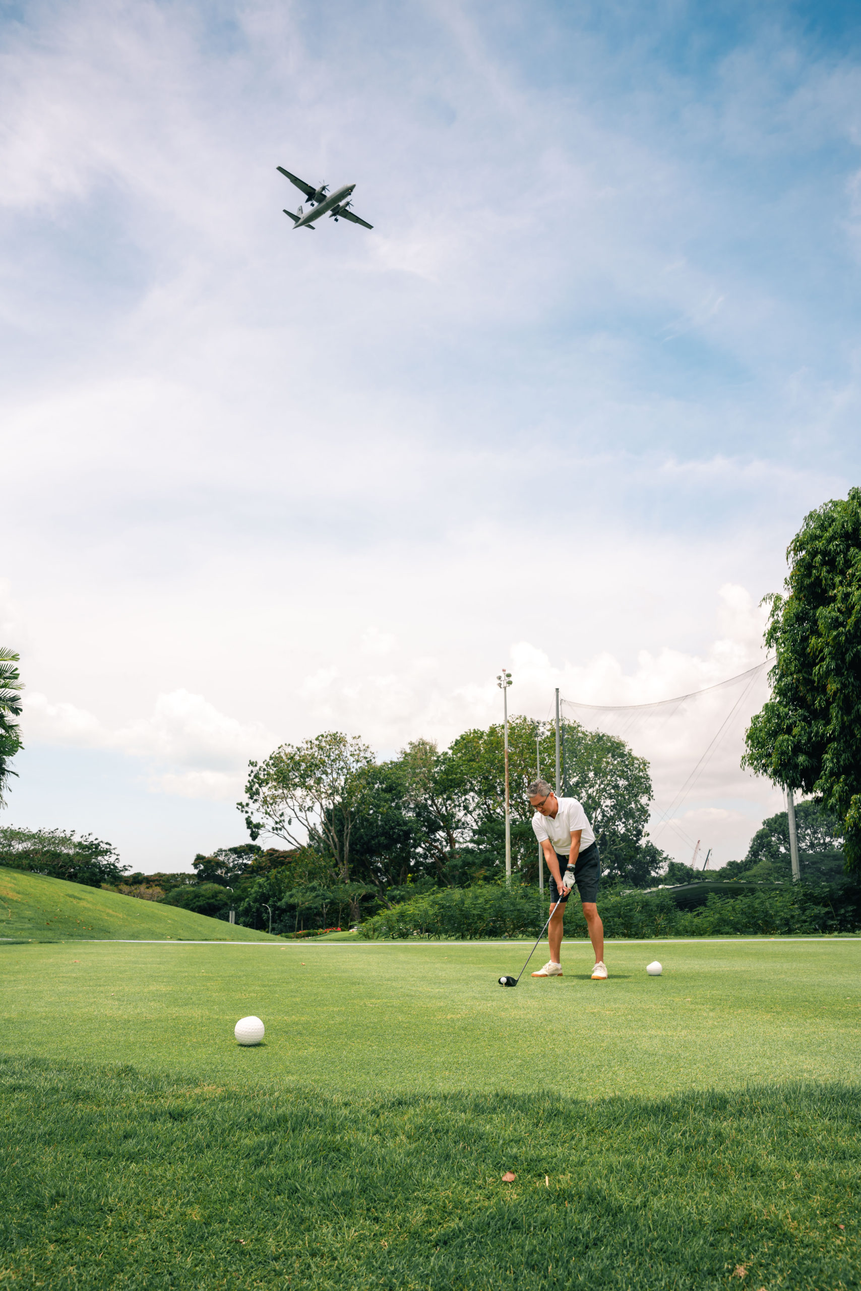 man at golf course with plane flying overhead during an event